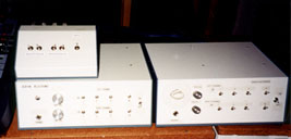 Here is a picture of two audible VU 
meters with a small switch box sitting on top of one of them. Each 
meter is a large rectangular box with nine switches and three knobs.
Caption: